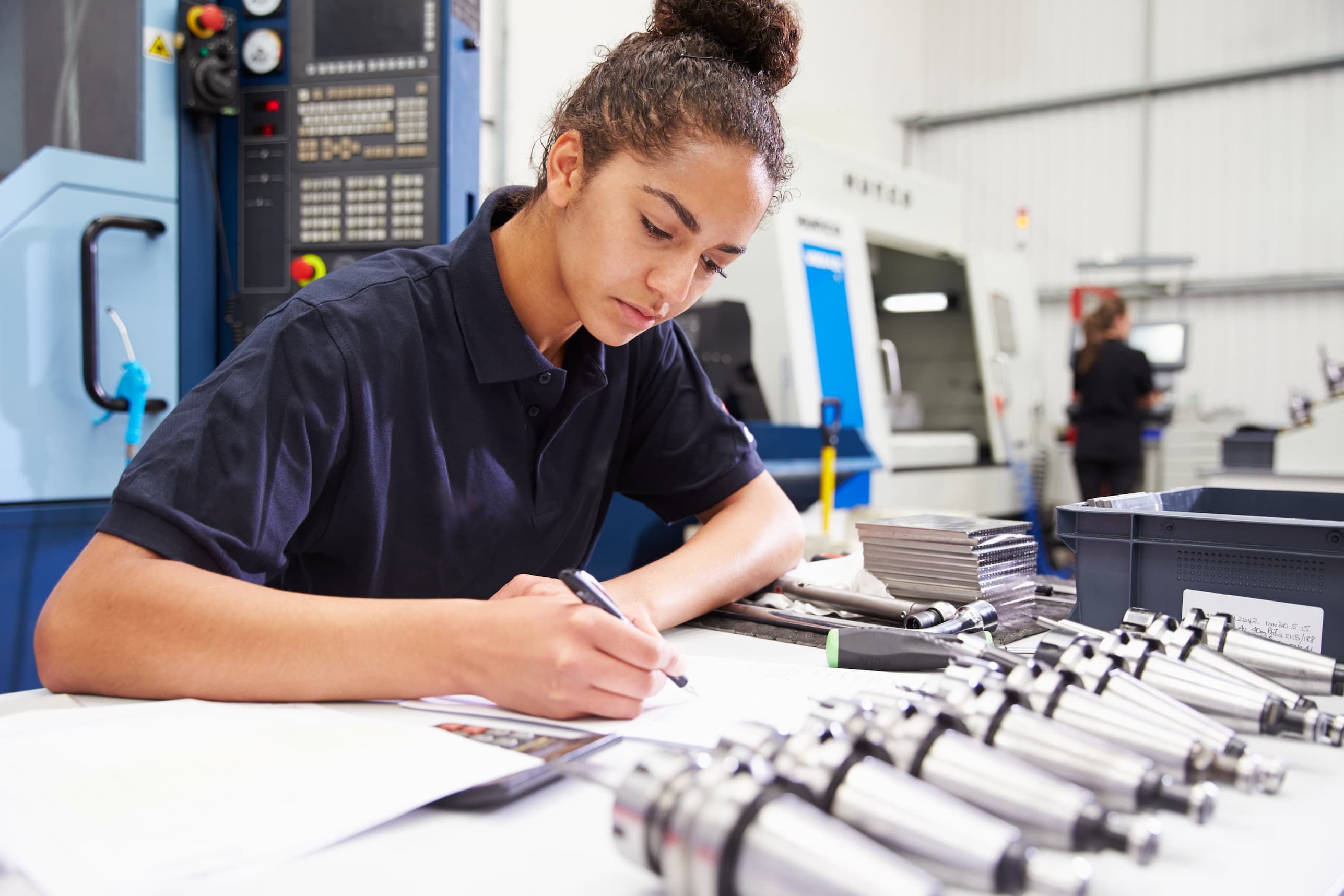 apprentice taking notes in a factory