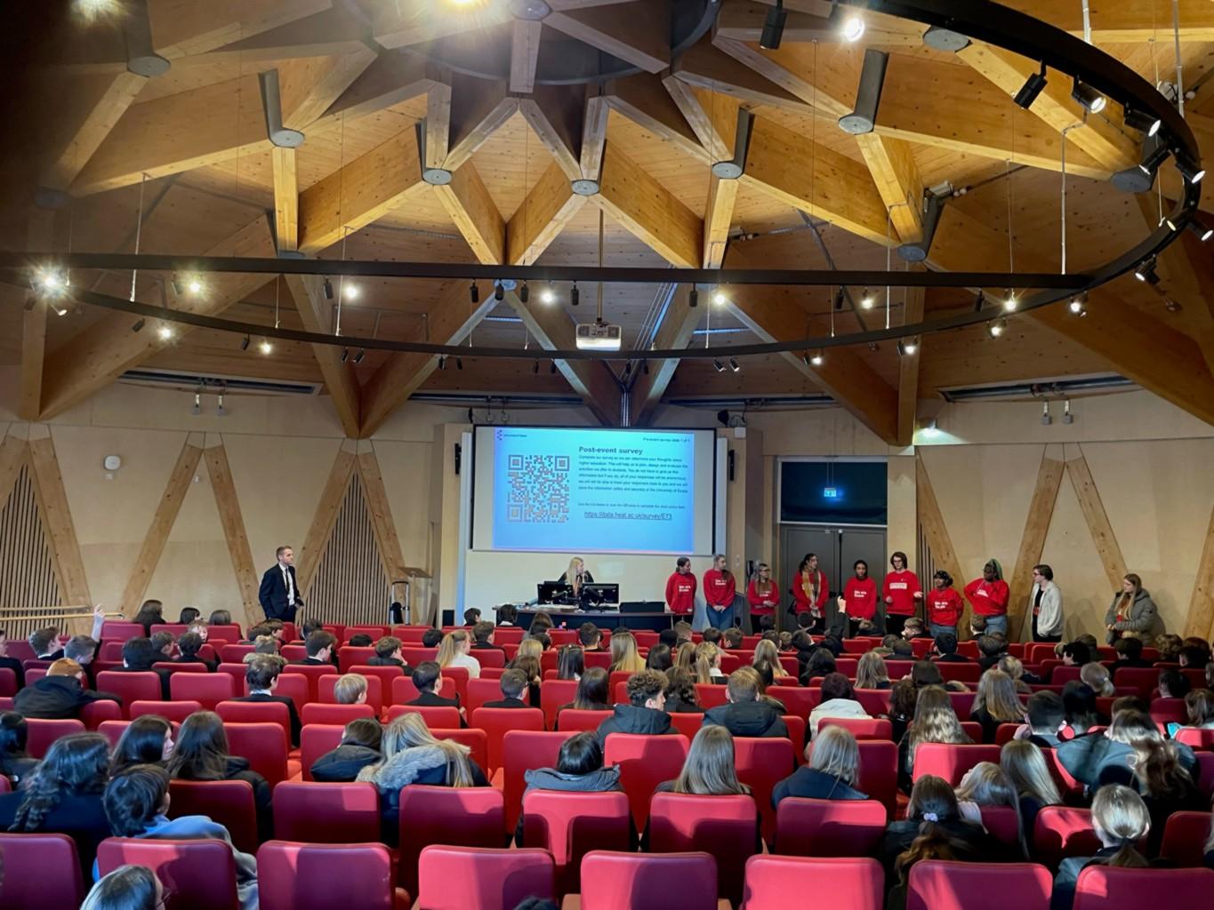 image of lecture theatre with presentation being given to seated audience